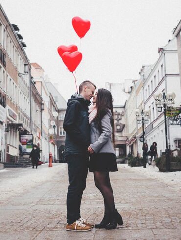 Koppel op straat met hartjes balonnen