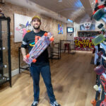 Wim Derksen met skateboard in zijn winkel