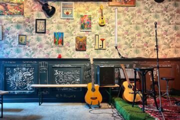 Café de Tuin: muur met gitaar en podium